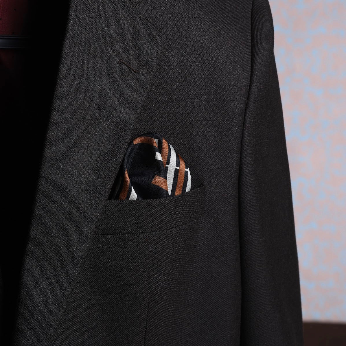 Striped black and brown scented pocket square tucked into suit pocket