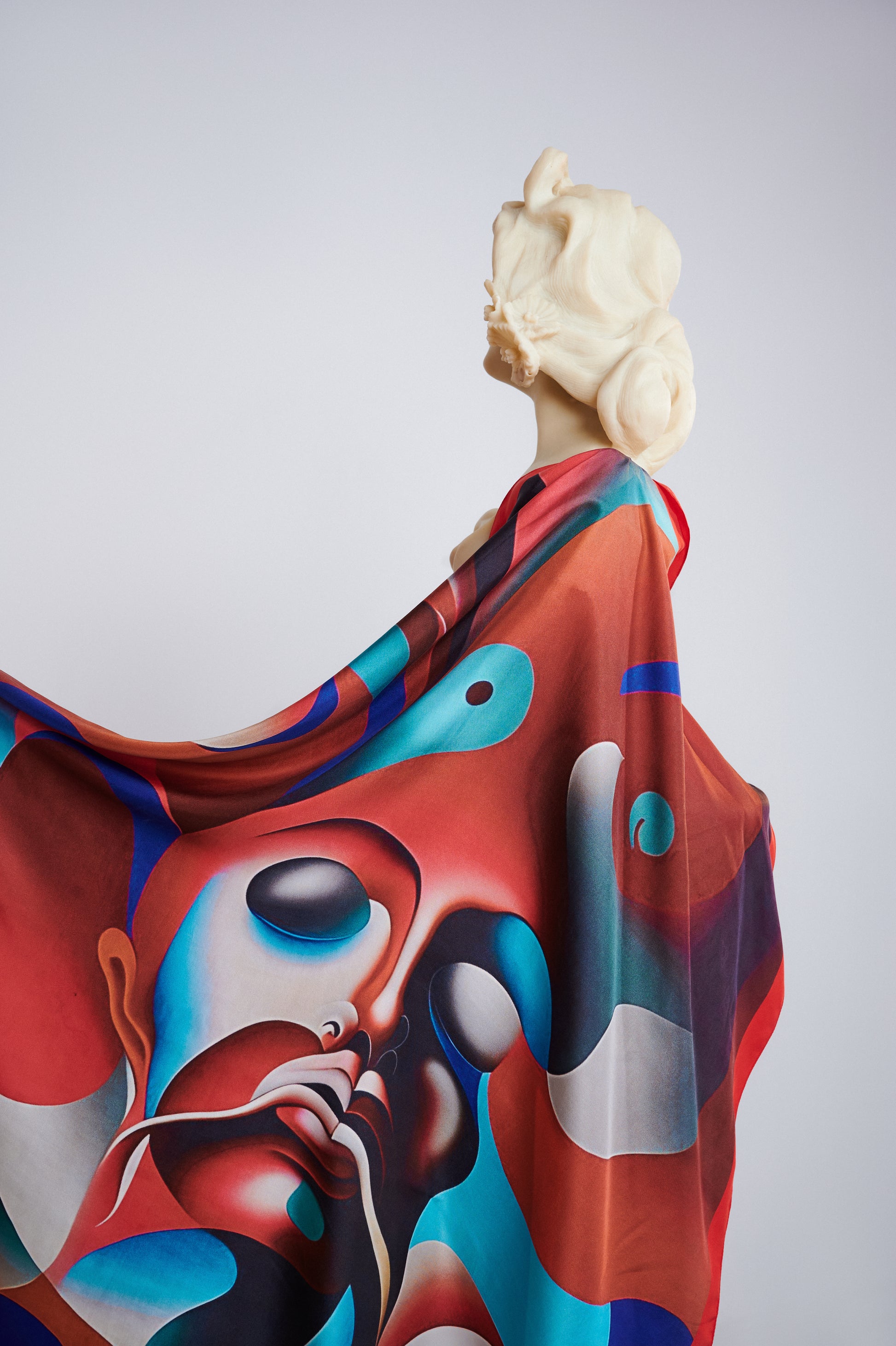 Bust statue adorned with Freeque's Furor scented scarf, showcasing the intricate details of the red and blue artistic face design.