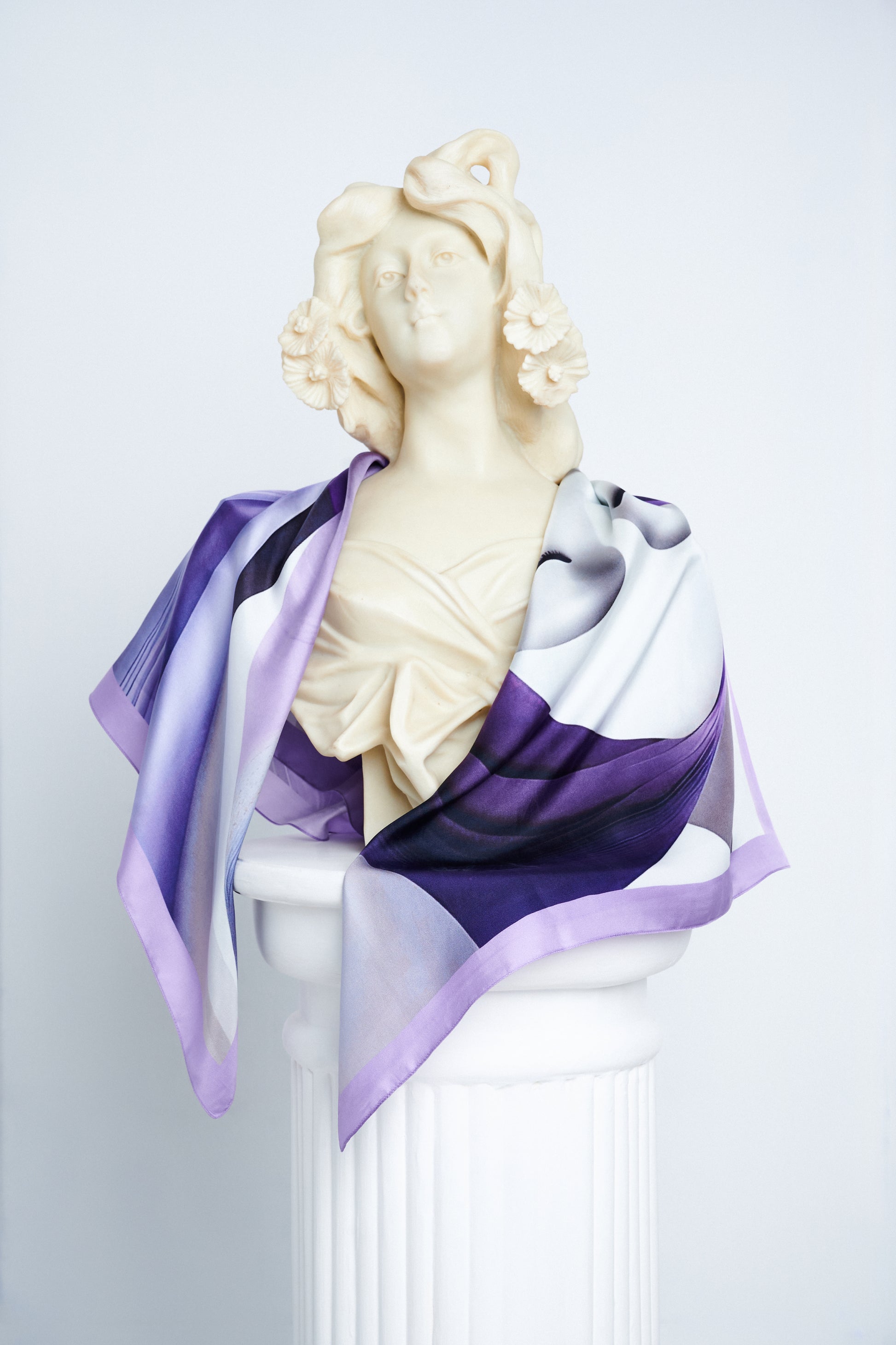 Voile D’Ombre luxury silk scarf draped over a Greco-Roman statue, embodying artistic elegance.