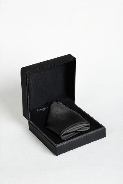 Solid charcoal satin silk pocket square displayed in a black box - fragrance-infused luxury accessory by Freeque.