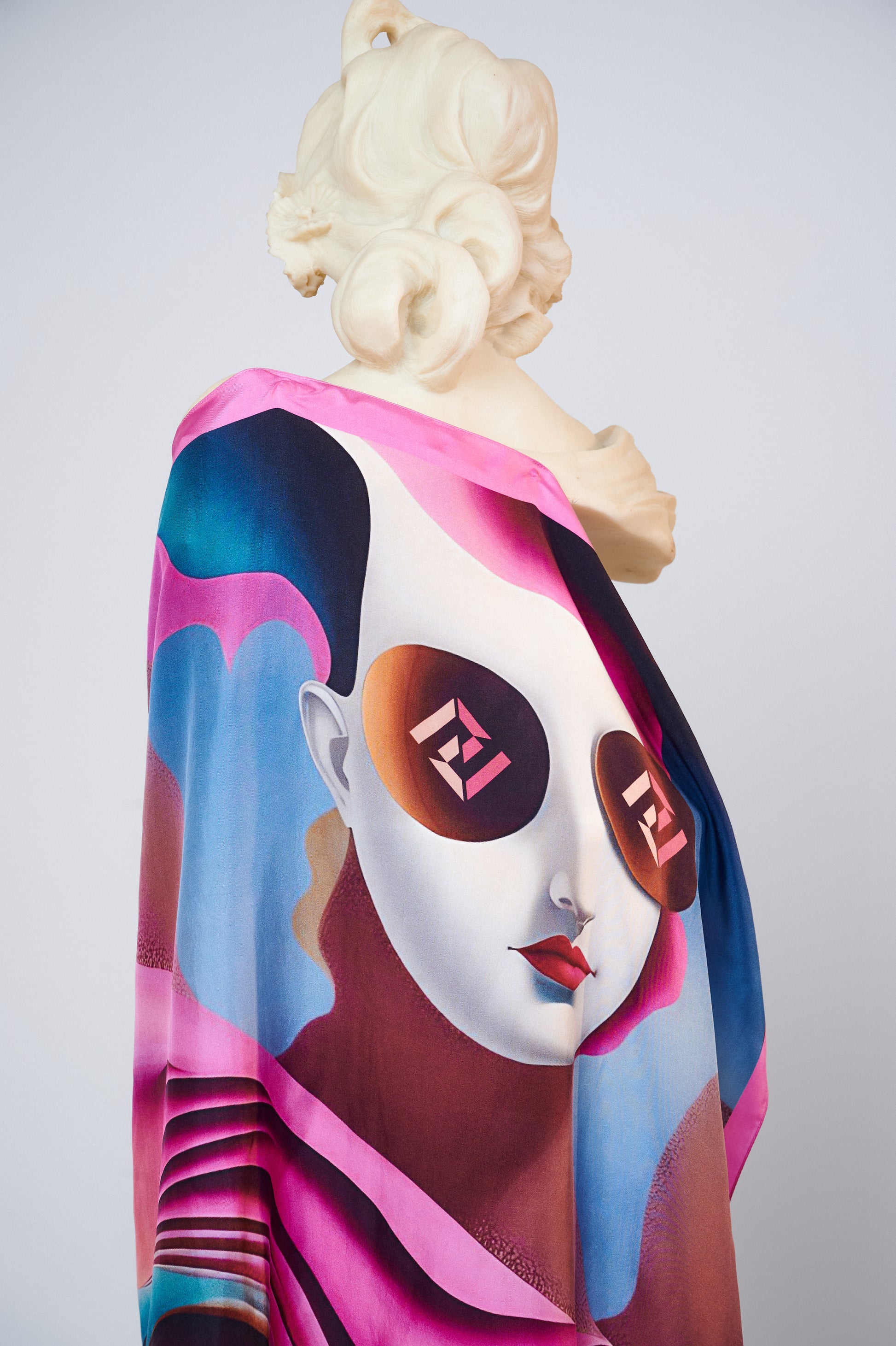 Freeque’s Soufflé luxury scarf in soft pastels, artistically draped over a classical statue, highlighting its silk craftsmanship.