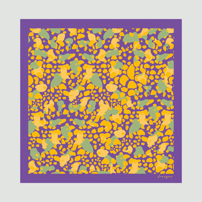 Flat-lay image of Auber'genius scented scarf displaying abstract yellow and purple pattern with green accents