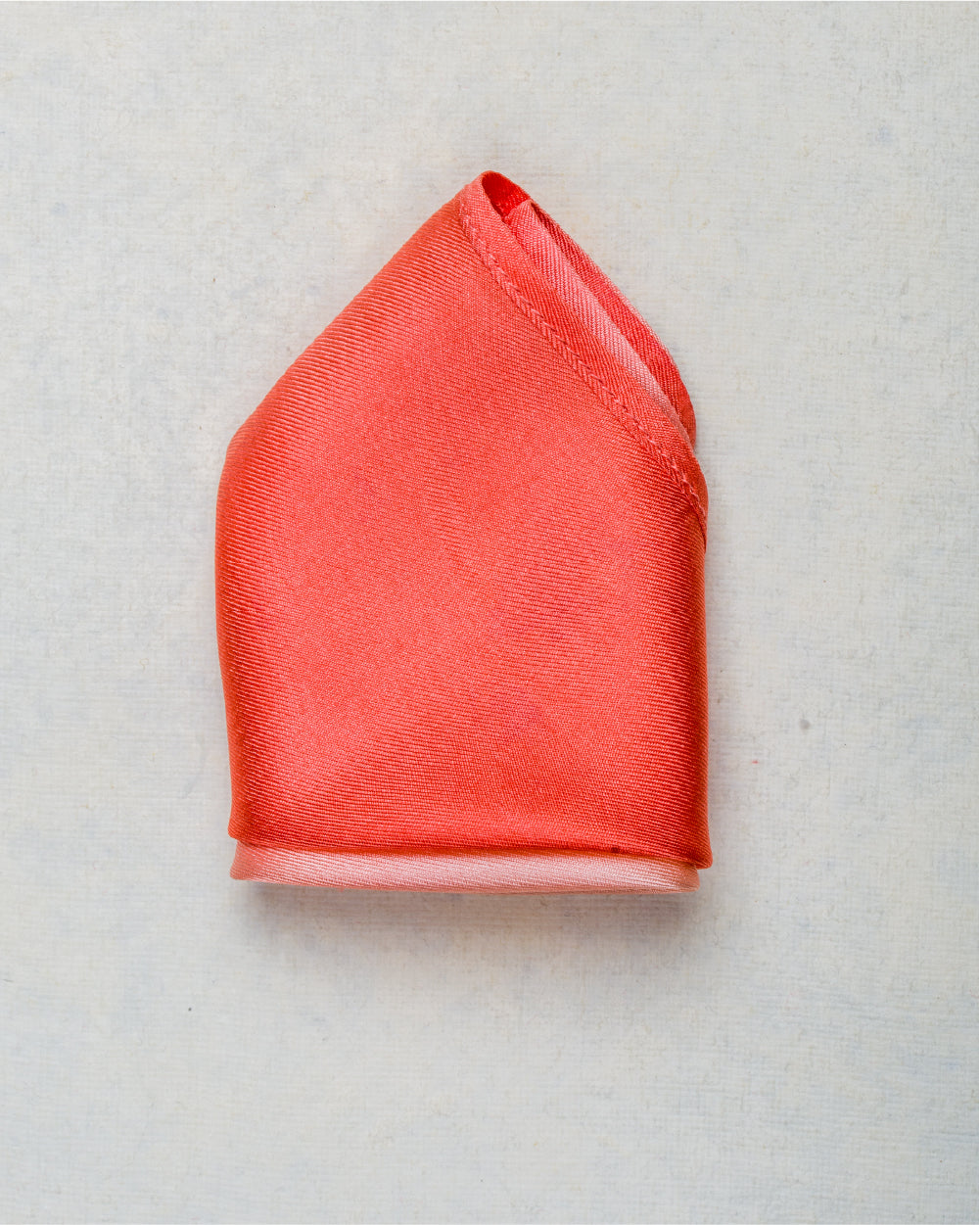 Close-up of ombre peach scented pocket square with rich, luxurious silk texture