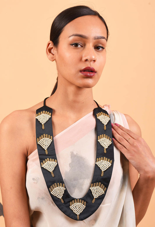 Image of model wearing Courtesy fine jewellery piece showcasing intricate handcrafted detailing against a soft beige background.