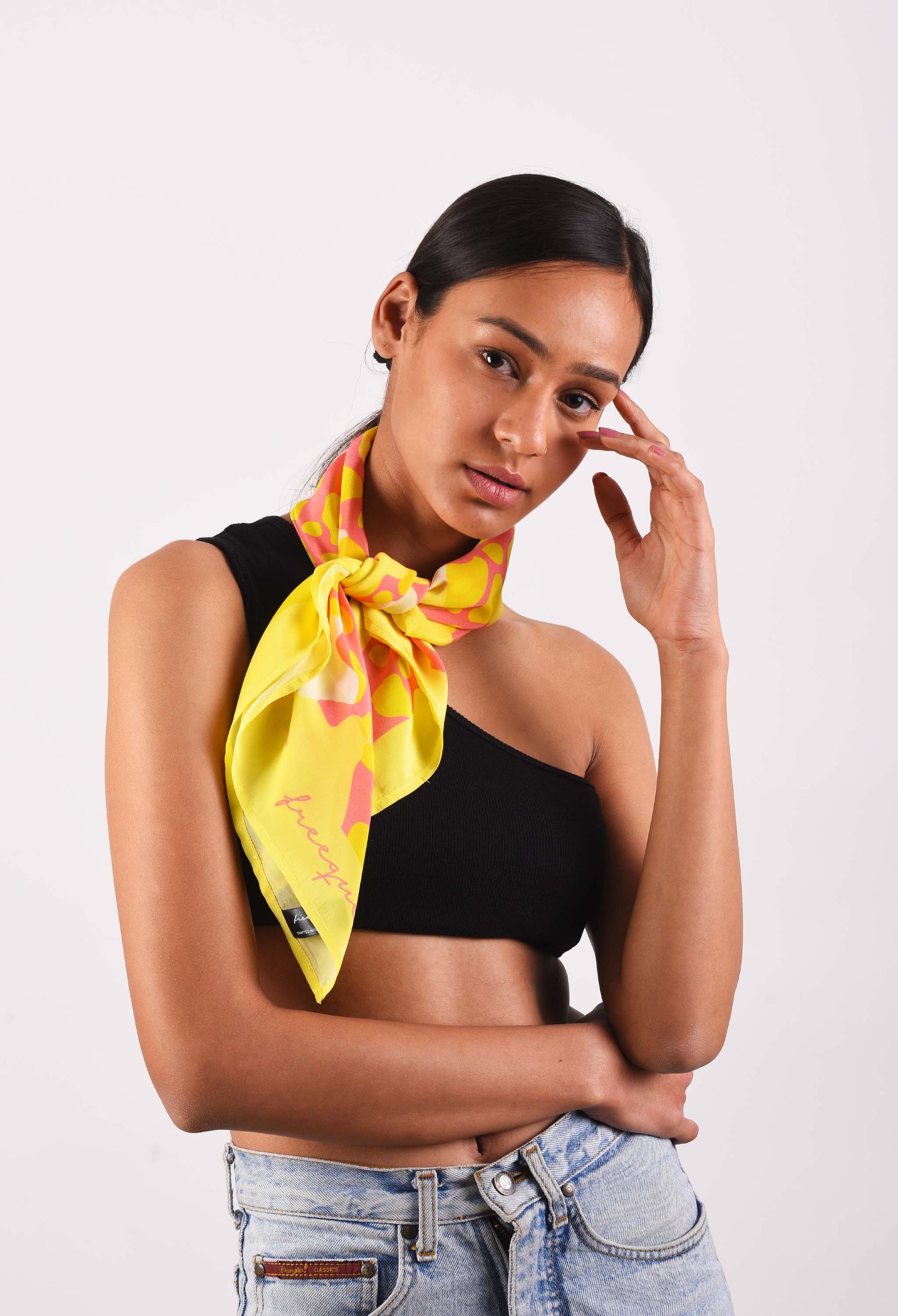 Model wearing Flamin'Gold luxury scented scarf in vibrant yellow and pink, styled around the neck
