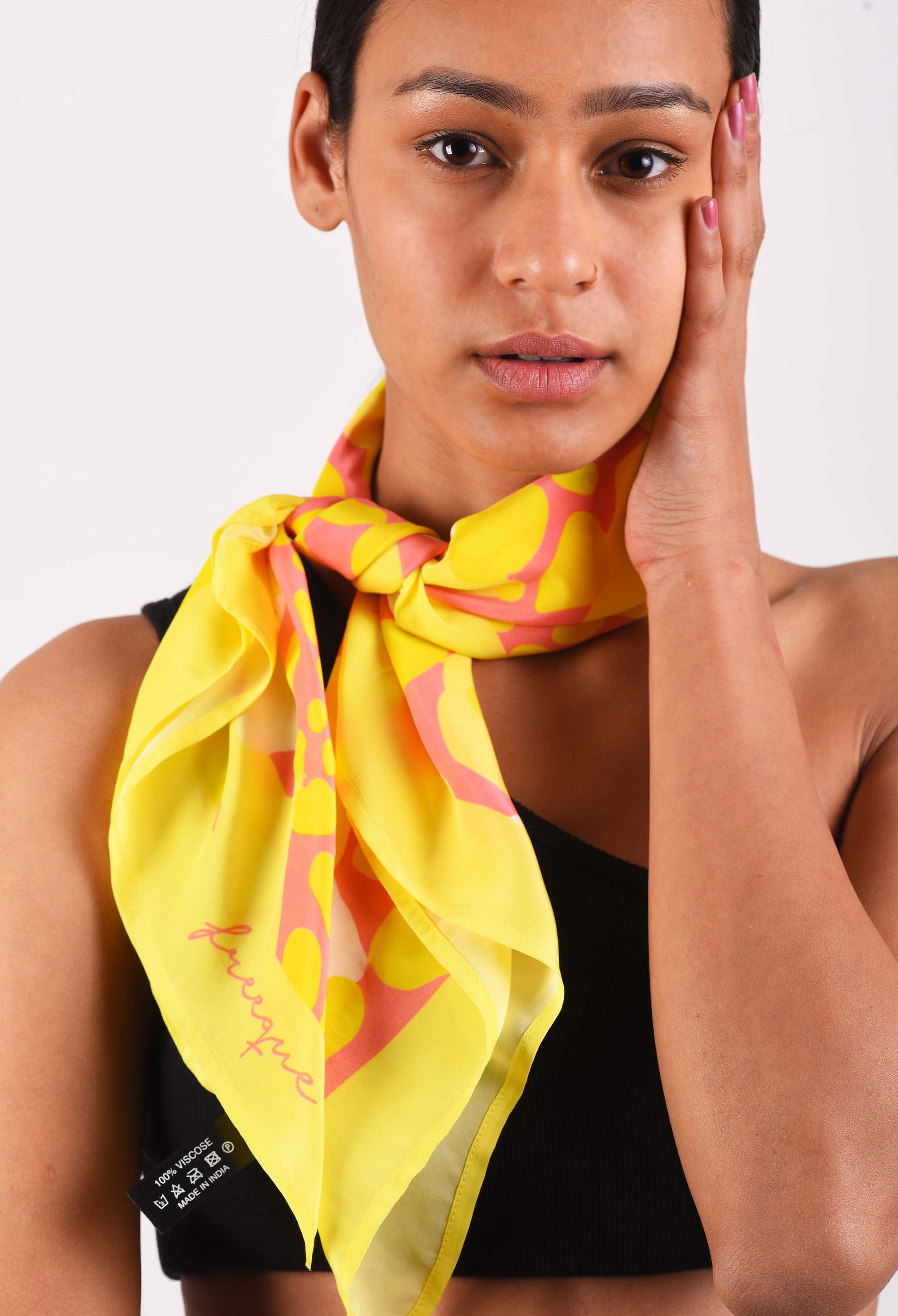 Close-up of model wearing Flamin'Gold luxury scented scarf with yellow and pink abstract design
