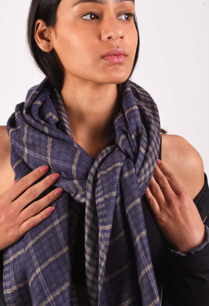 Close-up of Kai stole with checkered pattern in camel wool, wrapped around the model's shoulders.