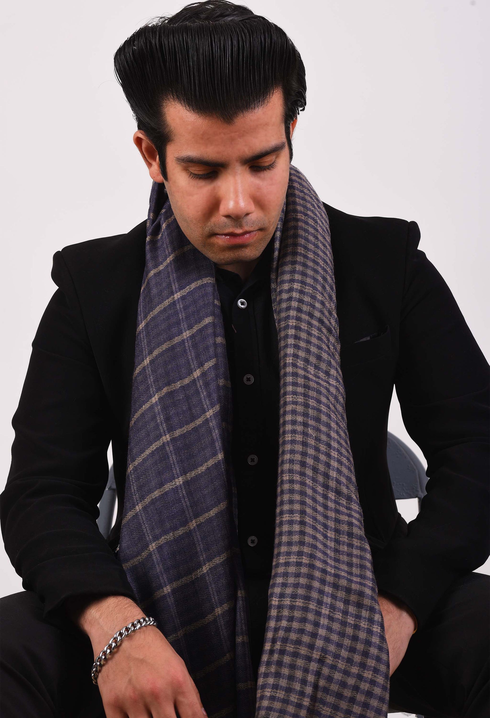 Model wearing Kai stole in camel wool, draped elegantly over a black suit.
