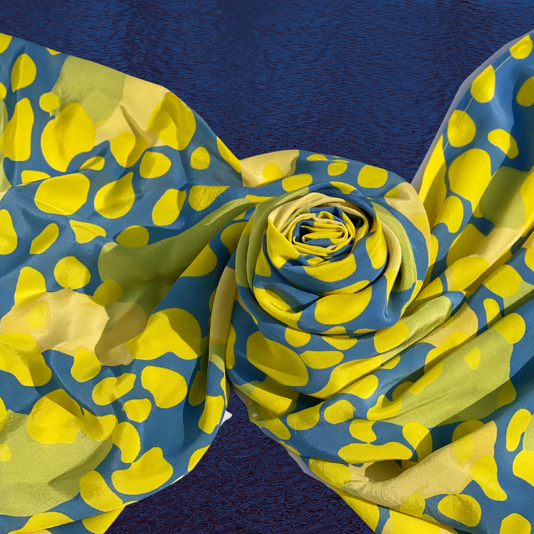 Close-up of Mirage scarf in a rosette fold showcasing rich yellow and blue hues
