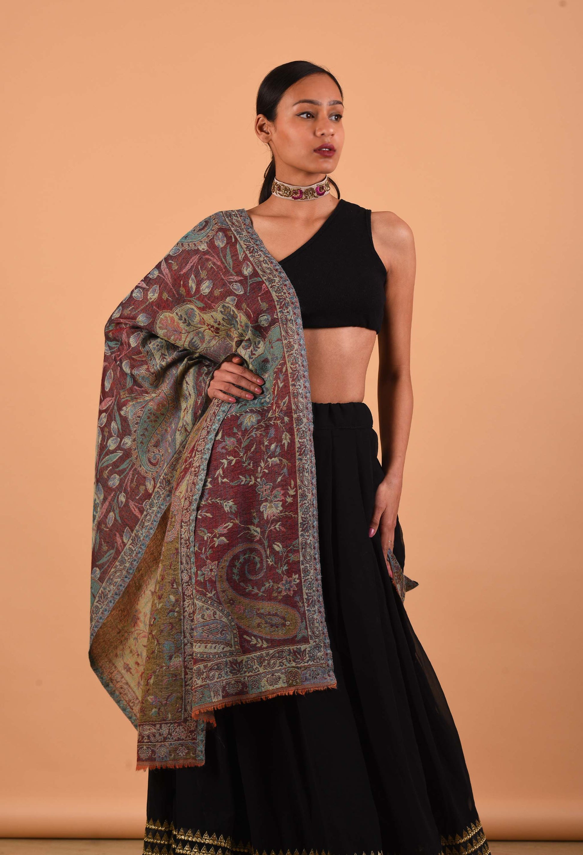 Naadira shawl draped elegantly over woman’s shoulders, showcasing detailed design