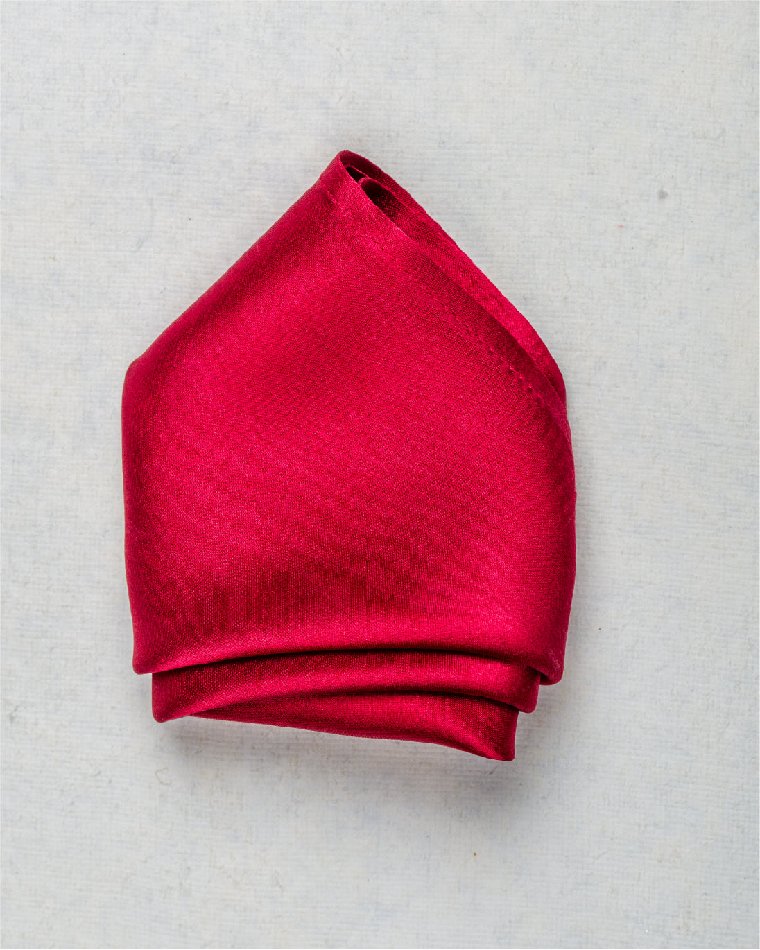 Close-up of folded solid red satin silk pocket square