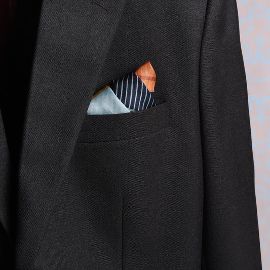 Striped Blue and Yellow Pink pocket square in a suit pocket for a luxurious touch